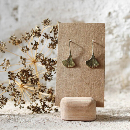 Boucles d'oreilles pendantes, feuilles de Ginkgo Biloba, en laiton, fabriquées par les Métalleuses en fusion. Vue de face.