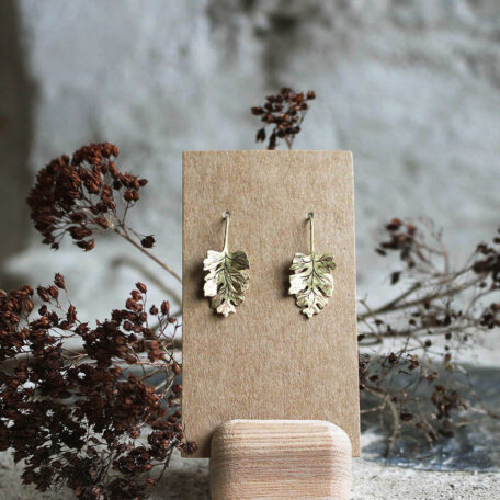 Boucles d'oreilles, feuilles de Camomilles en laiton. Fabriquées artisanalement par les métalleuses en fusion. Vue de face.