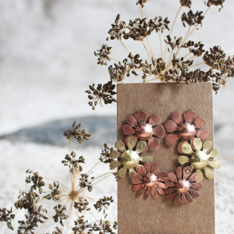 Boucle d'oreille Marguerites en cuivre laiton et argent, fabriquées artisanalement par les Métalleuses en fusion, photo frontale.