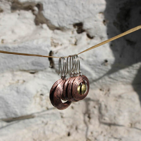 Boucles d'oreilles Tibet, en cuivre, laiton. Elles sont fabriquées artisanalement par les métalleuses en fusion. Vue de profil.