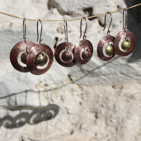 Boucles d'oreilles Tibet, en cuivre, laiton. Elles sont fabriquées artisanalement par les métalleuses en fusion. Vue frontale.