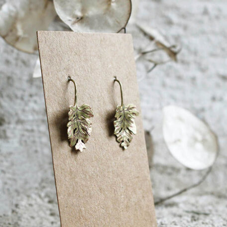 Boucles d'oreilles, feuilles de Camomilles en laiton. Fabriquées artisanalement par les métalleuses en fusion. Vue de coté.