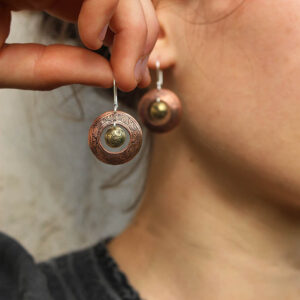 Boucles d'oreilles Tibet, en cuivre, laiton. Elles sont fabriquées artisanalement par les métalleuses en fusion. Vue sur le modèle.