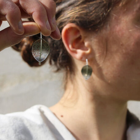 Boucles d'oreilles feuilles perfoliées en argent, fabriquées artisanalement par les Métalleuses en fusion. Photo porté.