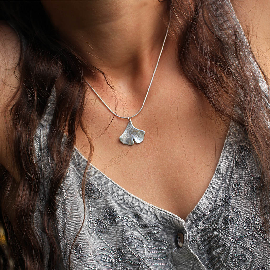 Pendentif Ginkgo Biloba en argent, fabriqué artisanalement par Les Métalleuses en Fusion. Photo collier porté.