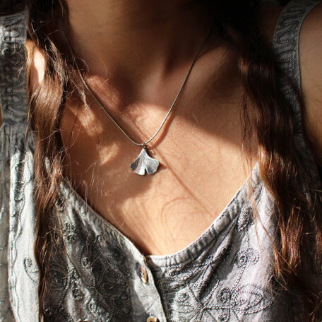 Pendentif Ginkgo Biloba en argent, fabriqué artisanalement par Les Métalleuses en Fusion. Photo avec du pendentif avec le modèle.