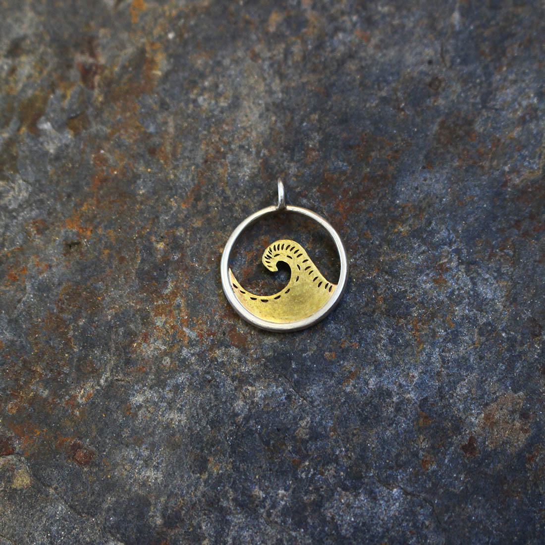Pendentif hublot vague en argent et laiton. Fabriqué artisanalement par les métalleuses en fusion.